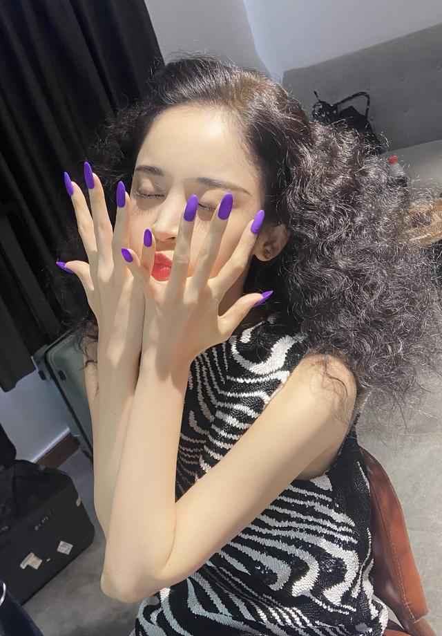 古力娜扎身穿斑马条纹上衣，爆炸头搭配紫色指甲，轻松美出国际范