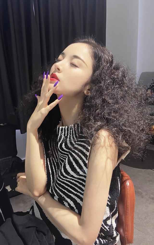 古力娜扎身穿斑马条纹上衣，爆炸头搭配紫色指甲，轻松美出国际范