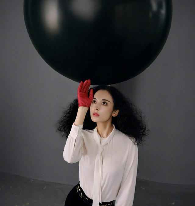 古力娜扎身穿斑马条纹上衣，爆炸头搭配紫色指甲，轻松美出国际范