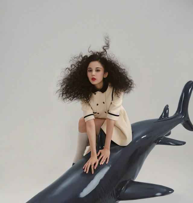 古力娜扎身穿斑马条纹上衣，爆炸头搭配紫色指甲，轻松美出国际范